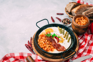 english breakfast with eggs, tomatoes, mushrooms, bacon, beans, and sausage
