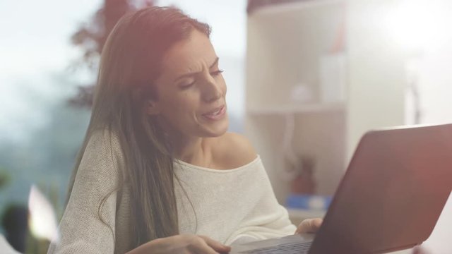  Attractive woman relaxing at home making video call on laptop computer.