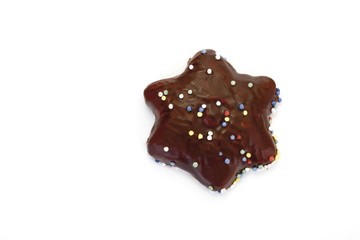 Chocolate coated gingerbread star biscuit with sugar pearls