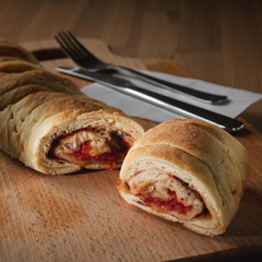 Delicious appetizing Vegetarian strudels on a black plate with parsley and ketchup, on a wooden board with a knife and fork