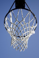 Basket ball basket covered in hoar-frost in front of a blue sky