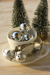 Christmas decoration with jingle bells on white wooden table.