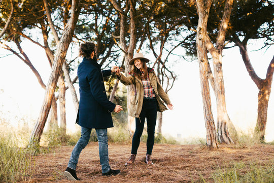 Young hipster couple dancing in the forest.