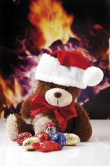 Teddybear with Christmas hat, chimney fire at back