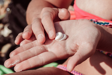 Beginning to apply sunscreen on the beach