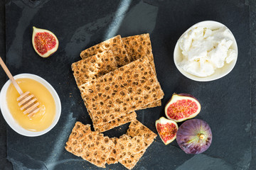 Healthy snack from wholegrain rye crispbread crackers, figs and ricotta cheese