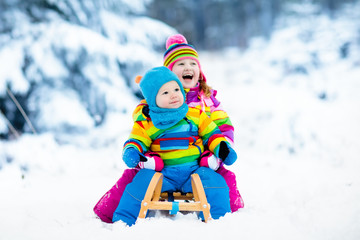 Fototapeta na wymiar Kids on sleigh ride. Children sledding. Winter snow fun.