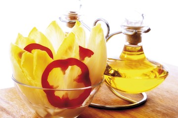 Chicory and red capsicum rings in a glass bowl, oil and vinegar