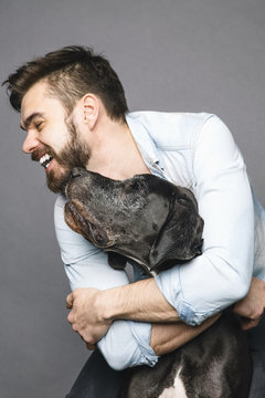 Bearded Man Hugging And Laughing With His Dog