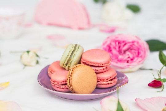 macarons and roses on an embroidered cloth