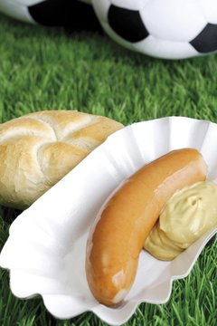 Bockwurst sausage with mustard and bread roll on a football turf