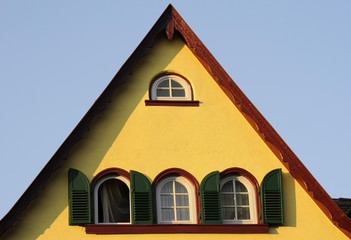 Yellow house, green shutters, red gable