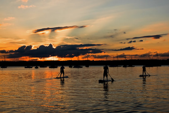 Drei Stand up Paddler im Starnberger See bei Sonnenuntergang