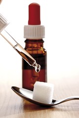 Dropping homeopathic medicine onto a sugar cube on a spoon