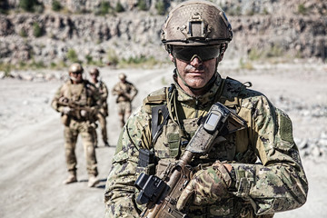 Fototapeta premium Team squad of special forces in action in the desert among the rocks