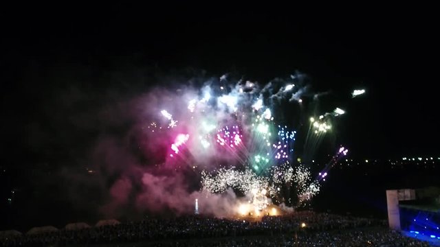 Slow-motion shooting of fireworks at a holiday by the river, aerial shooting