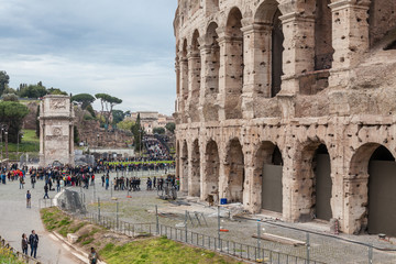 Fototapeta premium a view of Colosseum in Rome with trees on a sunny summer day and tourist