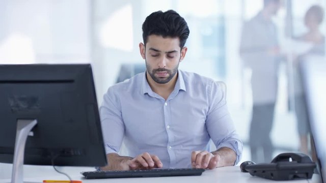  Businessman working on computer at his desk in modern office