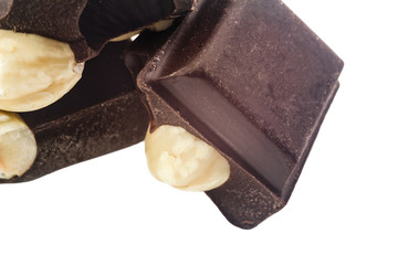 Pieces of bitter dark chocolate cubes with hazelnut isolated on white background