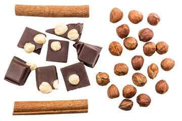 Pieces of bitter dark chocolate cubes with hazelnut and cinnamon stick isolated on white...