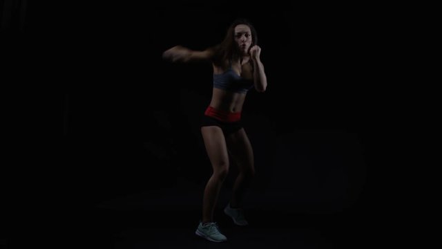  Female boxer training, throwing punches towards camera with bare fists