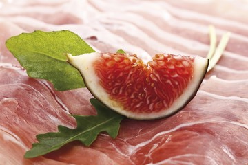 Fresh fig on raw ham garnished with rucola leaves