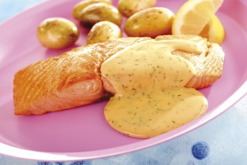 Grilled salmon with dill sauce and small, whole potatoes