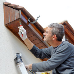 Homme peint sa maison