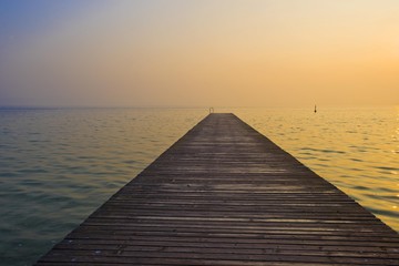 Wooden jetty on Lake Garda at sunrise, Sirmione, Lombardy, Italy, Europe