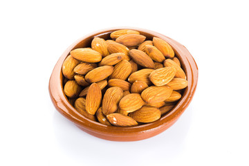 Group of almonds placed in a bowl on a white background