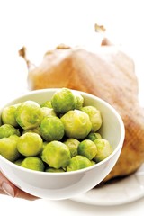 Sprouts in a bowl, out-of-focus roast christmas goose in the back