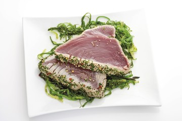 Seared tuna fillet with a herb crust on seaweed
