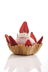 Strawberry ice cream, whipped cream and strawberries in a wafer bowl