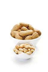Shelled and un-shelled peanuts in porcelain bowls