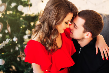 Fototapeta premium Woman in red dress with nice hair hug and kiss her husband on ch