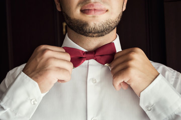 man butterfly clothes,businessman putting on  bow tie. Suit, Hands, care, tie, to correct, to adjust, fashion, bow.