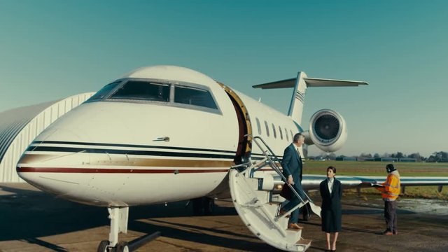  VIP Businessman disembarking from private jet & making phone call