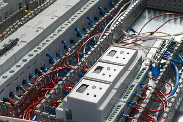 A series of modular magnetic contactors and a range of power circuit breakers. Between the rows of contactors and switches and devices, perforated cable channels. They laid the electrical wire.