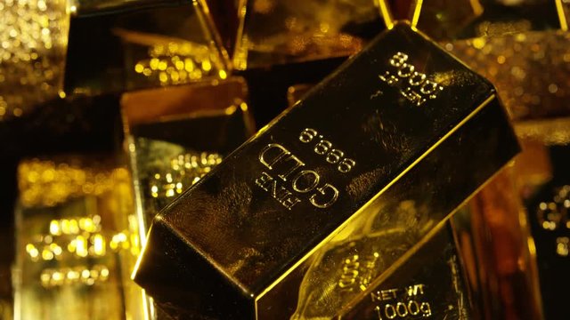  Close up gold bars on shimmering rotating stand, wealth & luxury concept.