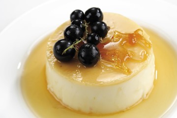 Creme caramel garnished with blackcurrant