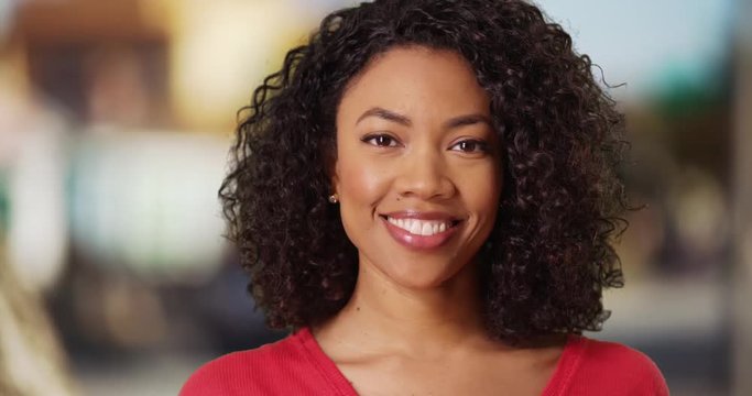 Close up of cute black female with curly hair and beautiful smile 