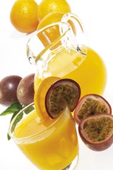 Glass and pitcher of freshly-squeezed orange - and passion fruit juice
