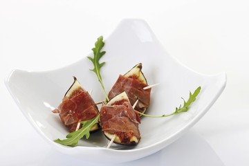 Fried figs topped with raw ham and rucola