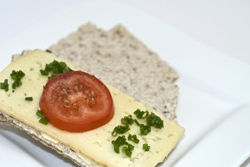 Crispbread with cheese, tomato and chives