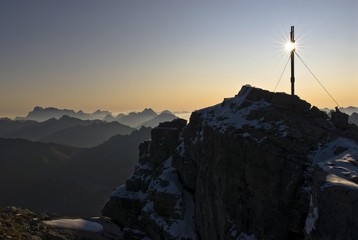 Summit cross in backlight with panoramic mountain view, Mount Namloser Wetterspitze, Namlos, Reutte, Tyrol, Austria, Europe
