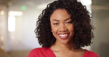Close up of cute black female with curly hair and beautiful smile indoors