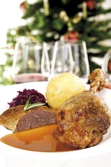 Fototapeta na wymiar Roast goose-leg and roast goose-breast with gravy, potato dumpling and red cabbage