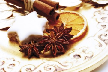 Christmas platter decorated with bound cinnamon sticks, a biscuit, a dried orange slice and dried star anise, Christmas decoration