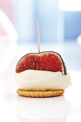 Finger food, mascarpone cheese and fig on a cracker