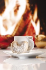 Coffee cup and Vanillekipferl biscuit, chimney fire at back